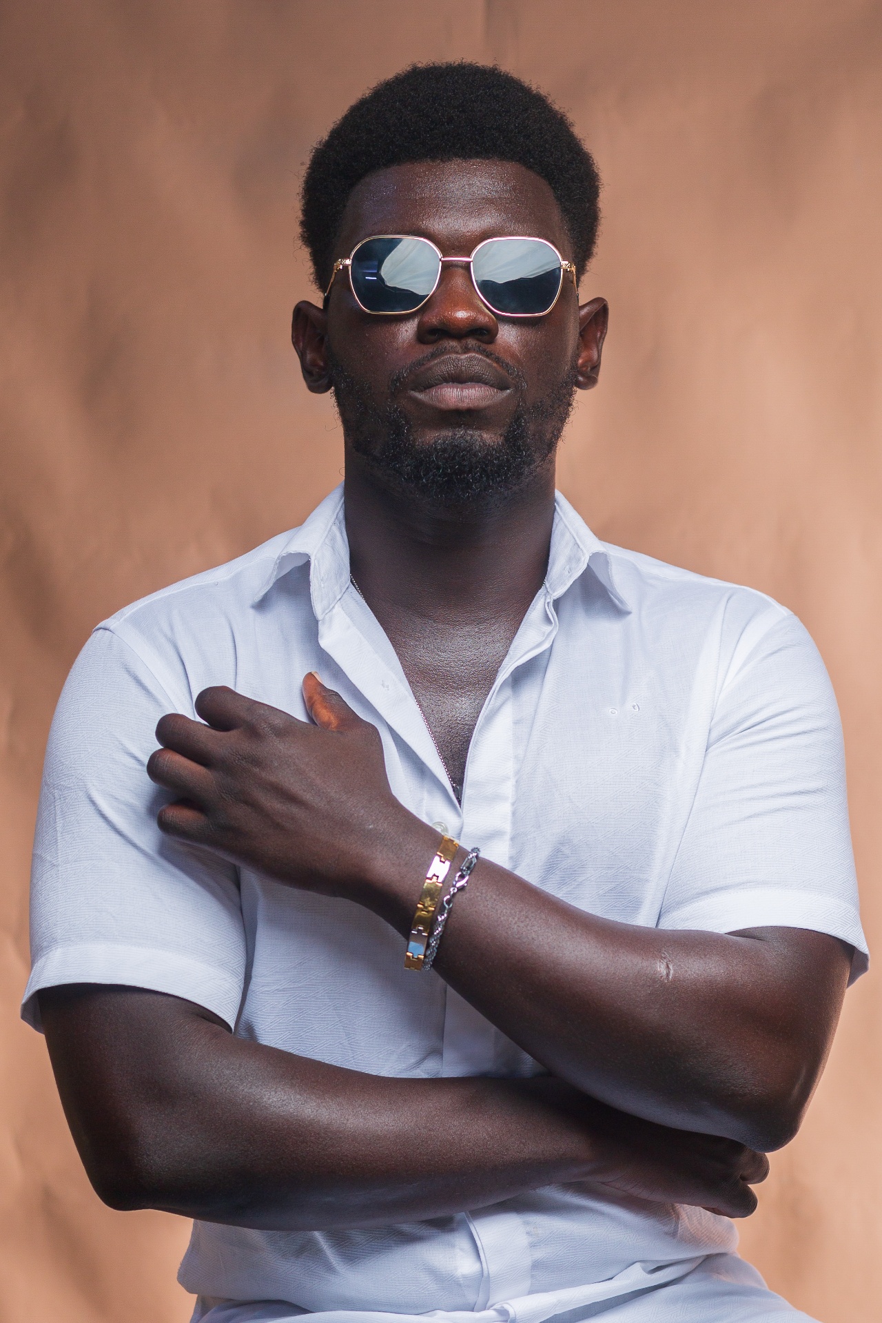 AjwogTHUM studio portrait in white shirt and gold-rimmed shades